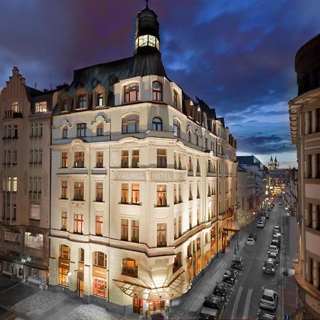 Art Nouveau Palace Hotel Praga Esterno foto The image shows a beautifully designed building at dusk. The structure features an elegant architectural style, with distinct elements like a tower or cupola at the top. The facade is illuminated, highlighting the intricate details of the design. The