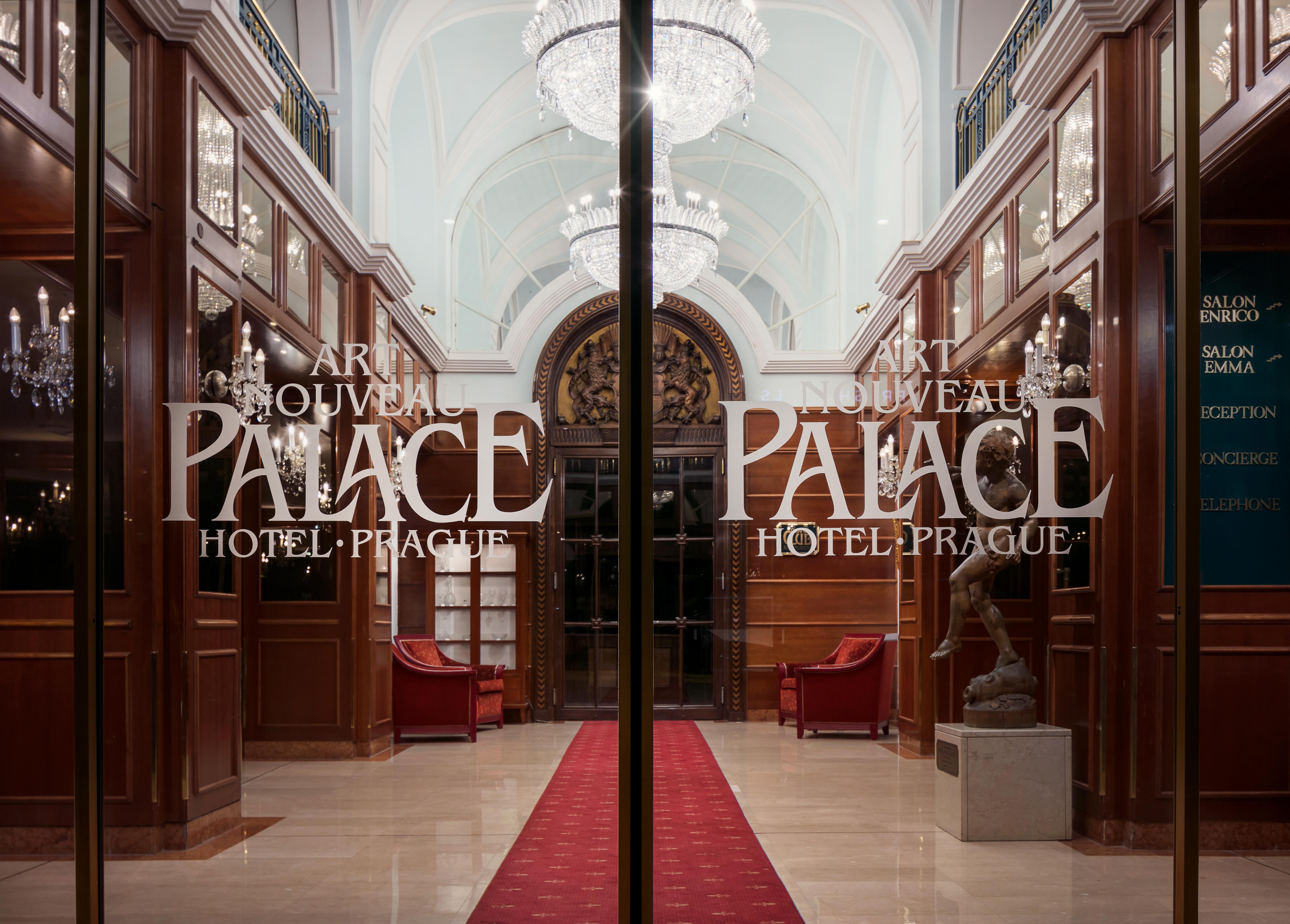 Art Nouveau Palace Hotel Praga Esterno foto The photo shows the entrance of the Art Nouveau Palace Hotel in Prague. The glass doors are decorated with the hotel's name and logo. Inside, there are elegant furnishings, including red seating and decorative chandeliers. The overall atmosphere conv