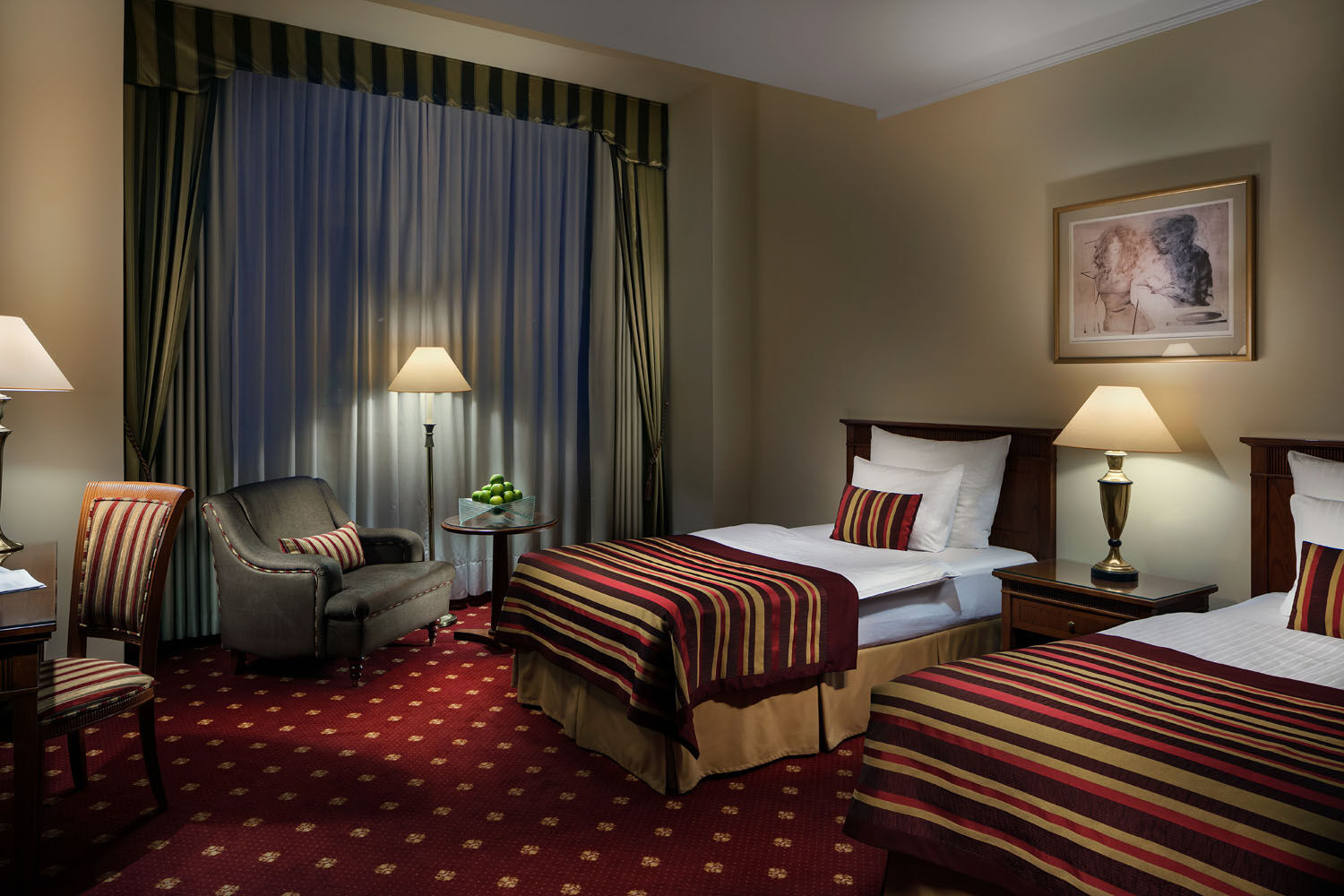 Art Nouveau Palace Hotel Praga Esterno foto The photo depicts a cozy hotel room featuring two single beds with striped bedding in shades of red, gold, and cream. There's a comfortable chair in the corner, along with a small table adorned with a decorative vase or plant. The room has large curt